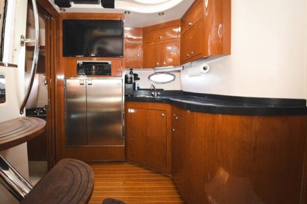 A kitchen with wood cabinets and black counter tops.