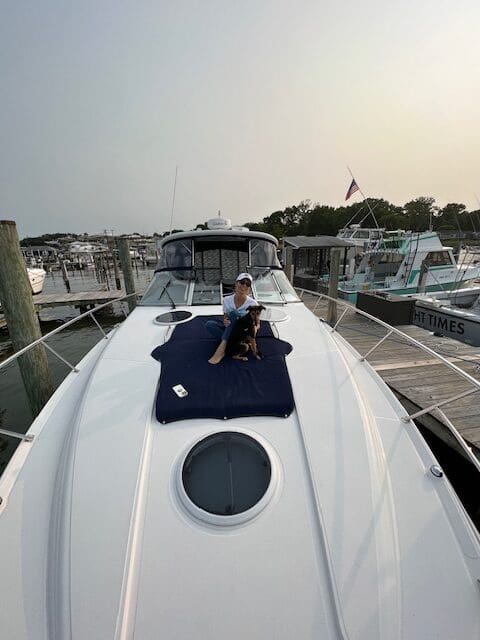 A man and his dog on the deck of a boat.